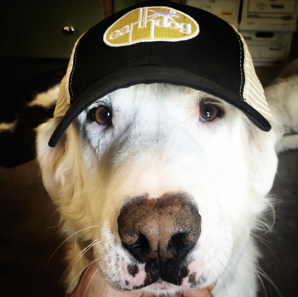 earthdog crew member benny sporting our eco friendly trucker hat