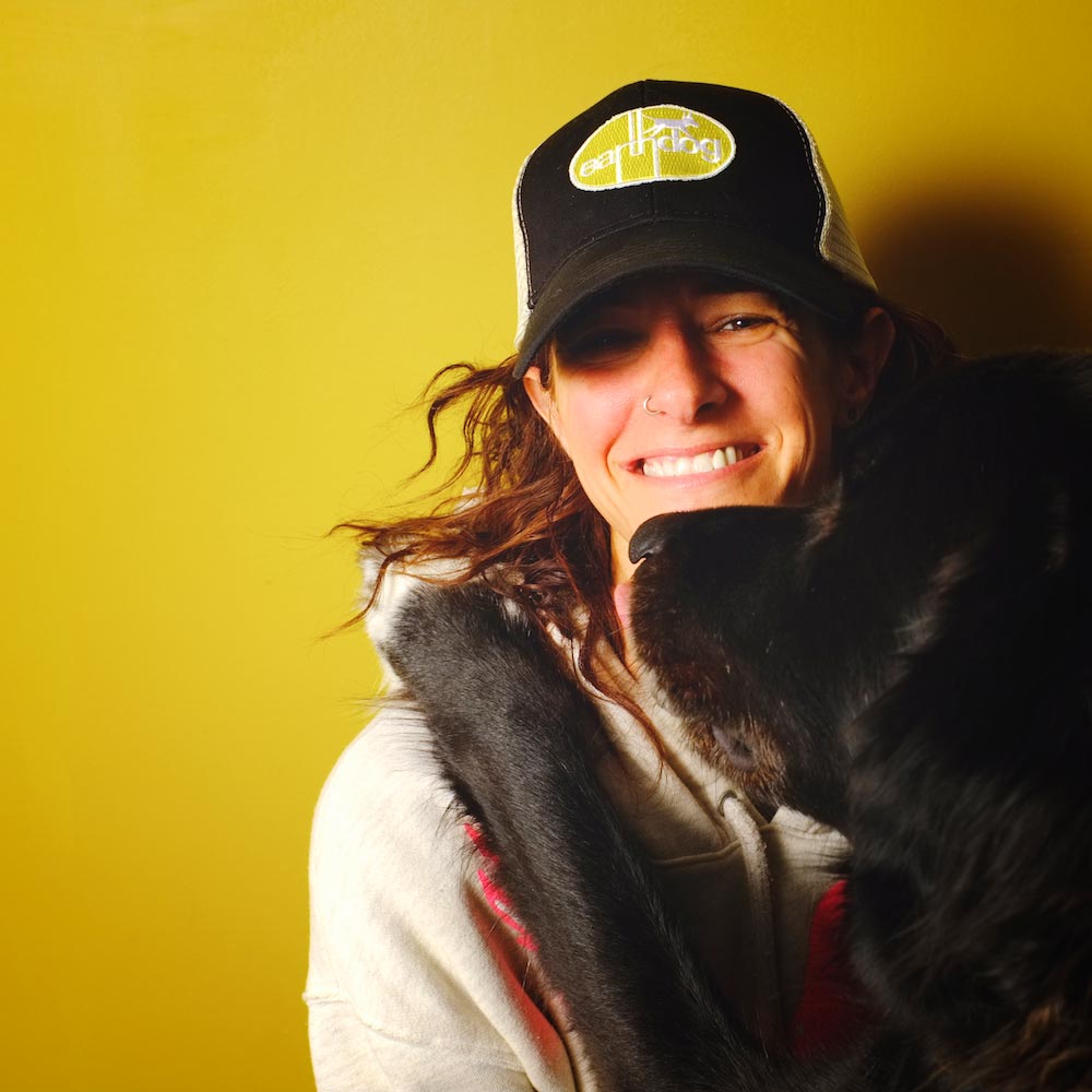 earthdog pack member odin with owner Kym wearing eco friendly trucker hat with embroidered logo patch